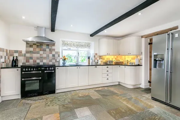 Modern well-equipped kitchen with granite work top and slate flooring